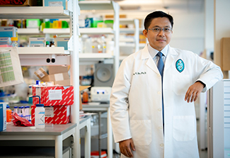 Photo of Dr. Tony Hu in a lab setting, wearing a lab coat
