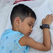 Photo of a young boy, sleeping as he wears an actigraphy watch