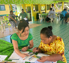 Courtney Choy assisting a woman lookin through documents