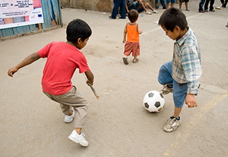 two boys playing with a soccer ball