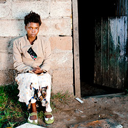 Photo by subman/iStock/Thinkstock. Xhosa woman in front of home in South Africa.
