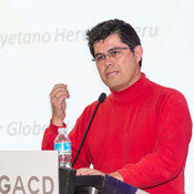 In the first photo on this page, Dr. Jaime Miranda, wearing a red shirt, stands at a podium as he lectures during a GACD meeting. 