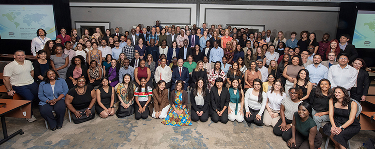 Image of a large group of people gathered in a room, smiling.