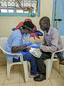 Dr. Immaculate Opondo (left) performing an oral exam in Kisumu, Kenya.