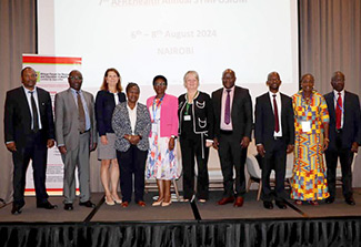 In this photo, Fogarty Director Dr. Kathy Neuzil (third from left) poses with other presenters at at AFREhealth’s Seventh Annual Symposium.