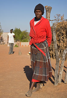Older African woman stands outside
