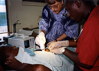 Archived photo of Francis Collins performing surgery while volunteering in Africa early in his career