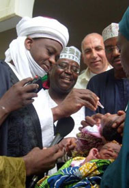 Group of men administer vaccine to infants
