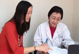 Dr Evelyn Hseih, pointing at paper, confers with Dr Zhang Pin
