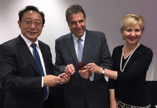 Dr. Xuetao Cao hands a gavel to Dr. Alain Beaudet, Dr. Glenda Gray looks on