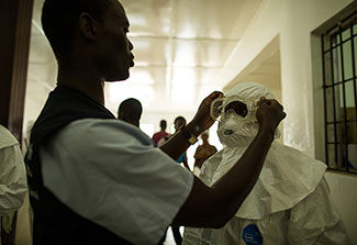 Healthcare workers put on personal protective equipment in Liberia
