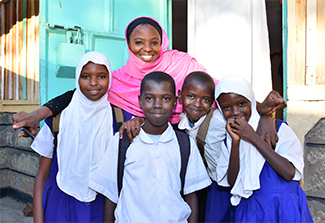 Five smiling African teens, three girls and two boys