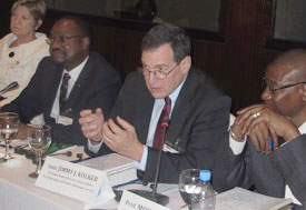 U.S. Ambassador to Mali Jimmy Kolker speaks, seated at conference table, people seated on both sides