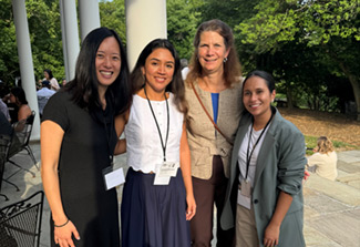 This photo shows Kathleen Neuzil (second from right) posing outside the Stone House on the NIH campus with former and current Fogarty Global Health Fellows at the 2024 LAUNCH program orientation.