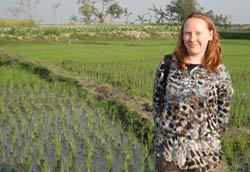 Dr. Juliet Pullium  stands in front of a field