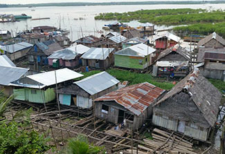 Homes in the slums in Peru built on logs adjacent to river.