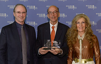 Tom Hutton and Mara Hutton of the Geoffrey Beene Foundation pose with Roger Glass, who holds his award