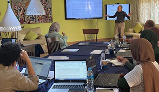 Dr. Henry Silverman standing in front of a table of a students as he teaches