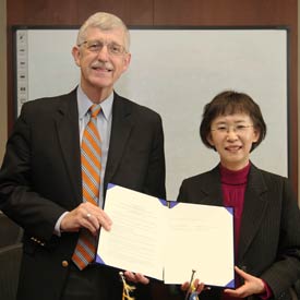 NIH Director Dr Francis S Collins and Korean official Dr Kyung-Hwa Ko hold up document for camera