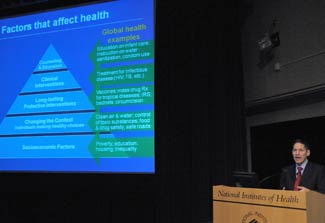 CDC Director Dr. Thomas R. Frieden speaks, slide projected to his left