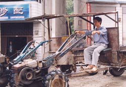 Chinese man sits on parked tractor