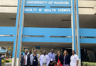 This photos shows Kathy Neuzil, director of the Fogarty International Center, (second from the right) and Fogarty program director, UnJa Hayes (third from the right) posing with faculty and trainees outside the University of Nairobi's Faculty of Health Sciences building.