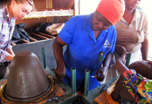 Groups of women work to mold the clay water filters