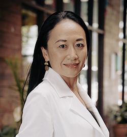 The photo on this page is a headshot of Rie Yotsu wearing a white lab coat