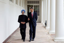 Indian Prime Minister Singh and U.S. President Obama walk side-by-side along a corridor, speaking to each other