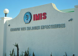 Photo: Outside of tan buliding, GHESKIO's second site, sign reads 'IMIS / Institut des Maladies Infecteuses'