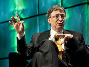Bill Gates, seated, speaks, moving hands expressively