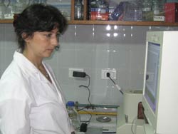 Dr Rajal in a lab coat looks at a computer monitor in a laboratory