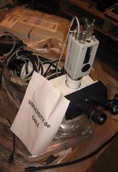 Close up of pile of scientific equipment and wires partially covered with clear plastic wrapping