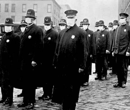 a black and white photo of Seattle police wearing flu masks standing shoulder to shoulder, during the 1918-1919 pandemic.