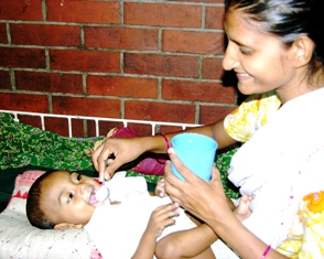 A Bangladeshi woman giving her baby a spoonful of a solution of water, salt and sugar. Photo: ICDDR, B