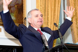 Sen. Jack Reed, D-R.I., with arms open wide, describes Fogarty's influence to the audience.